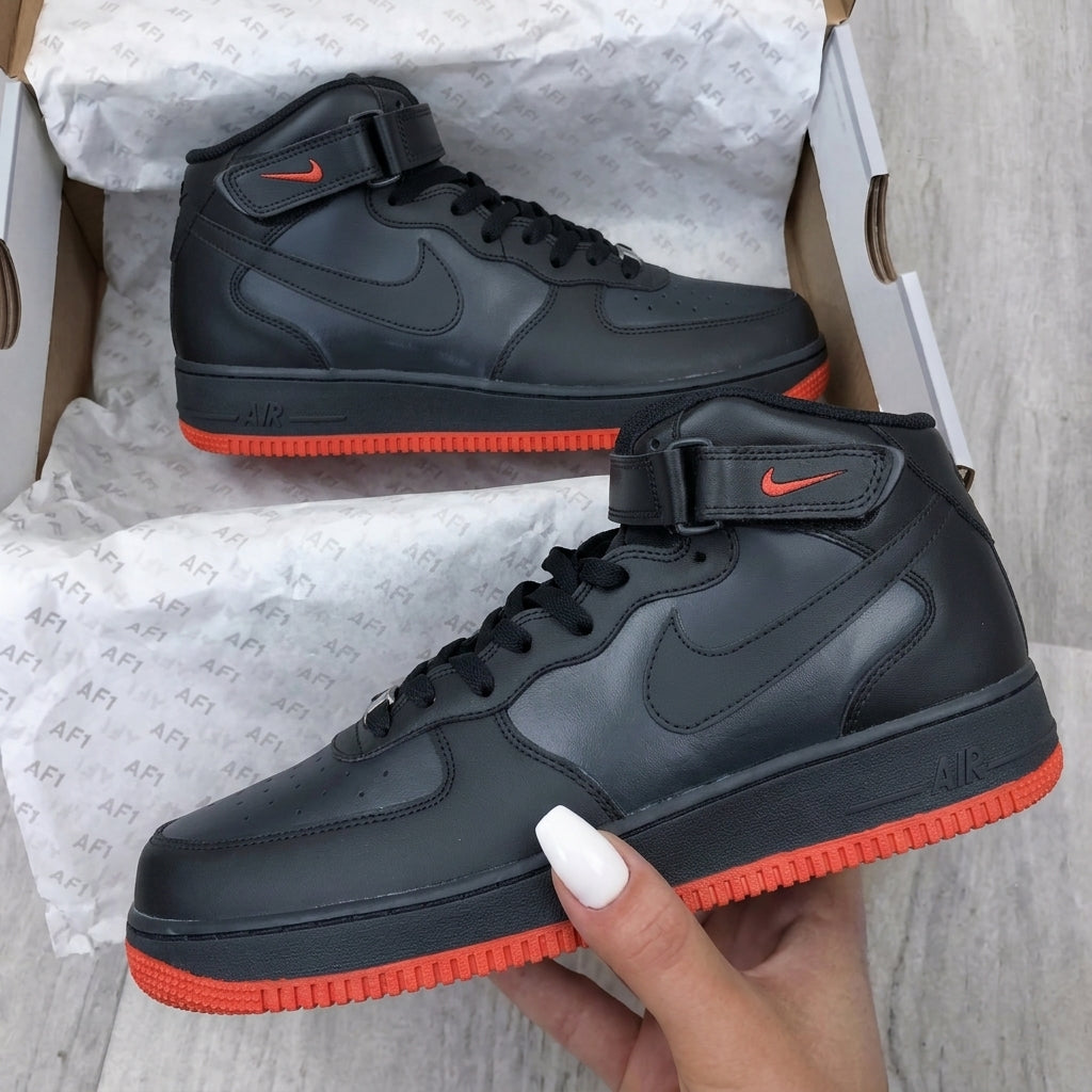 Black high-top sneakers with red soles on a white background